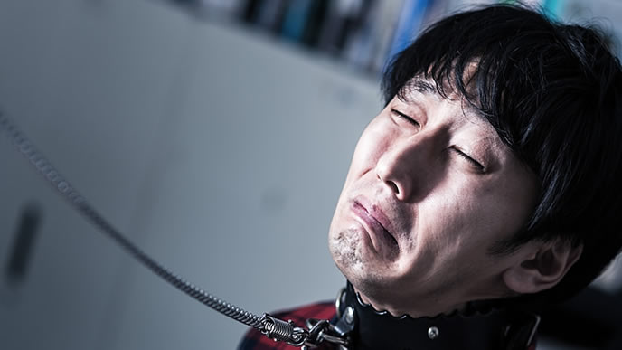 会社に繋がれている男性