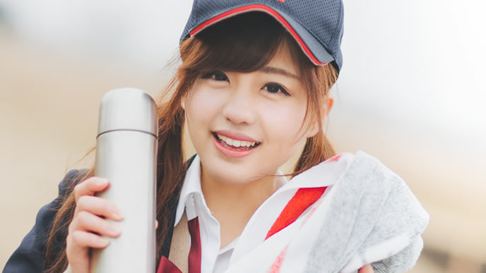 スポーツドリンク持参で応援する女性