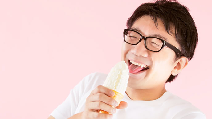 満点の笑顔でソフトクリームを食べる男性