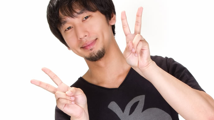 良い事がありダブルピースをする男性