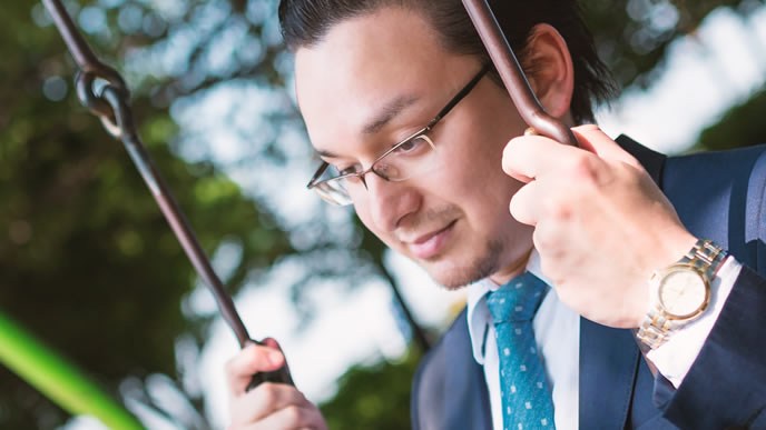 公園のブランコで気分転換をしている男性