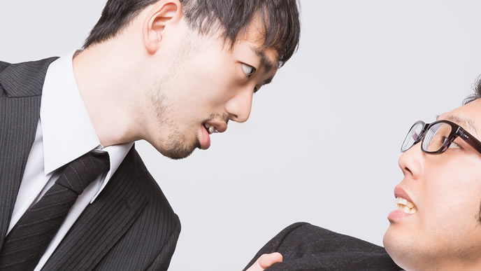上司に食って掛かる部下の男性