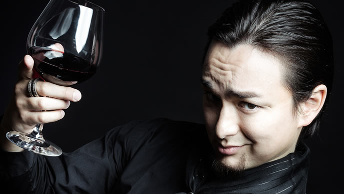 ワイン片手にニヤっとする男性