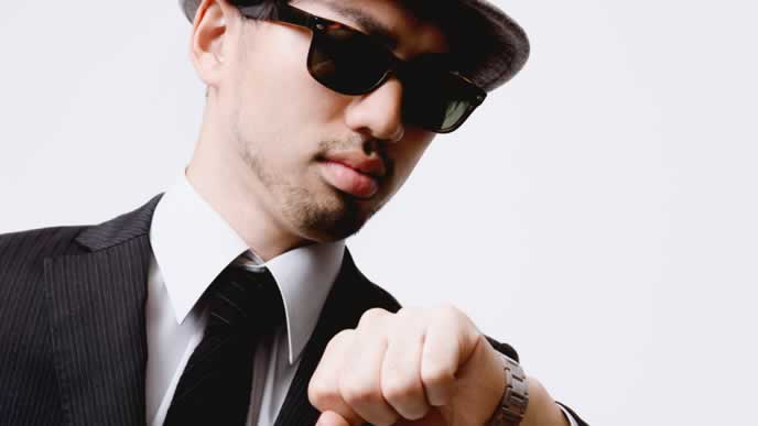 時間を確認する黒服の男性