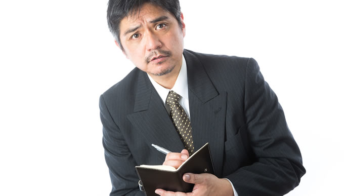 必死にメモをとる中年男性