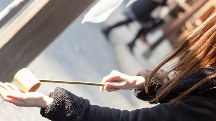 神社でお清めをする女性