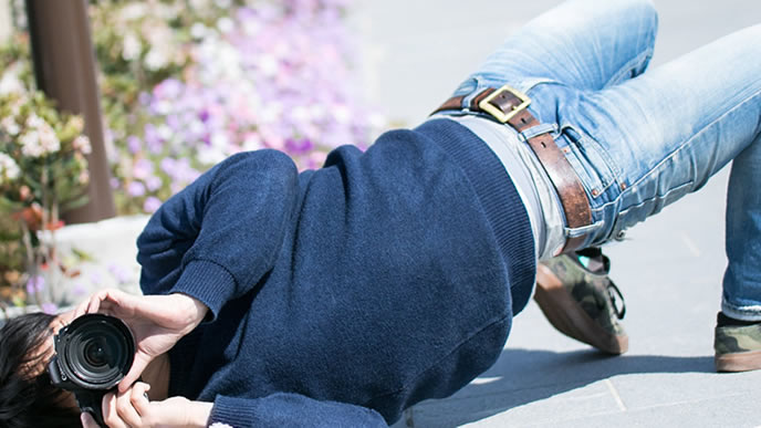 集中し過ぎてエビ反りで撮影するカメラマン