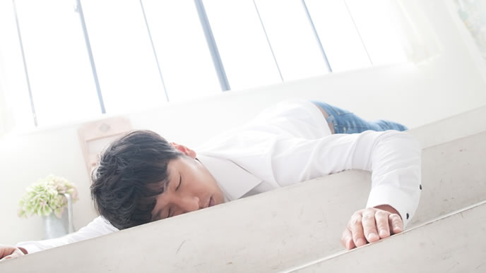 床で寝落ちする男性