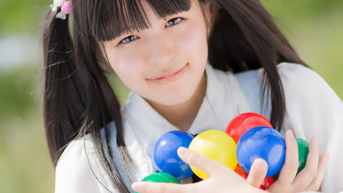 いっぱいのカラーボールと夢を持っている少女