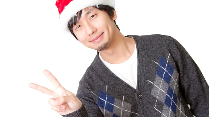 時期はずれのサンタ帽でピースする男性