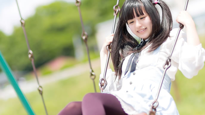 仕事が暇すぎてブランコに乗る女性