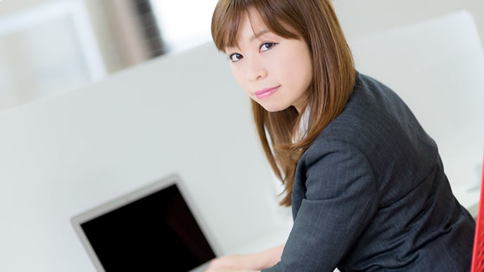 上司にメールを送った後に振り返る女性