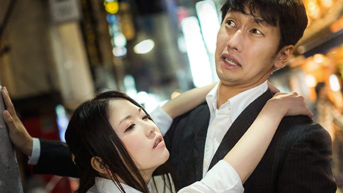 飲み会で上司に絡まれる男性