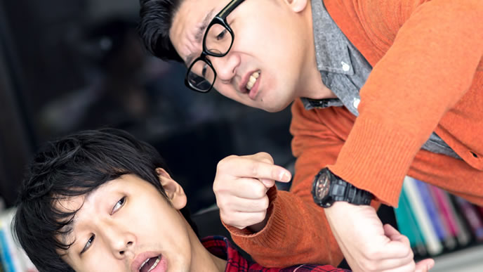 時計を指差して催促する男性