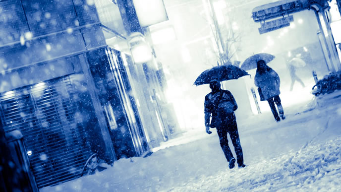 雪の中を歩くビジネスマン
