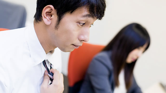 同僚と一線を引く男性