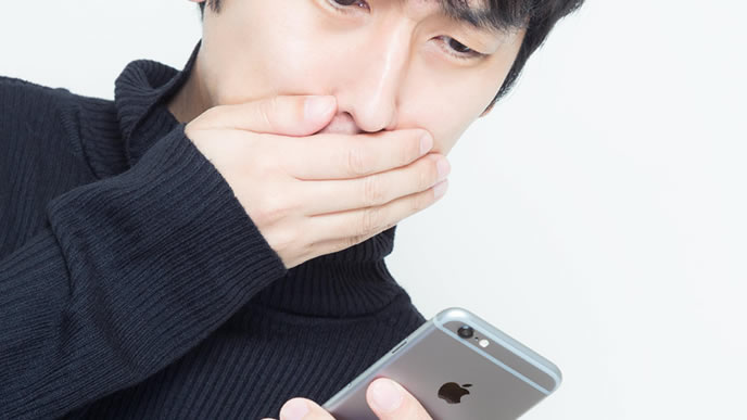 スマホでメールを送る男性