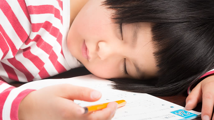 疲れ果て眠りにつく小学生