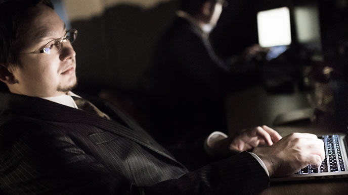 深夜の仕事で目を酷使する男性