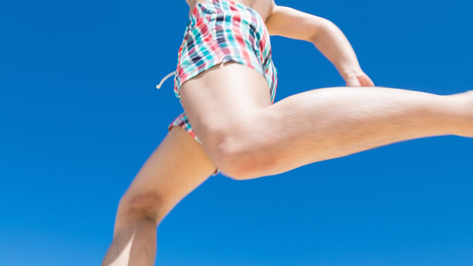 夏の青空で日光浴をする男性