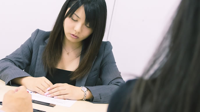 会議中に居眠りをしているのがバレている女性