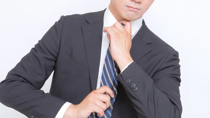 大きな商談に向けてネクタイを締め直すビジネスマン
