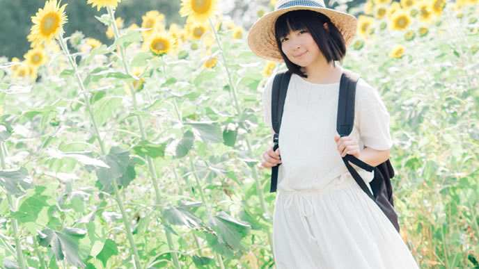 ひまわり畑を歩く心が晴れやかな女性