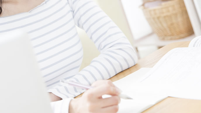 時候の挨拶を書き始めるOL