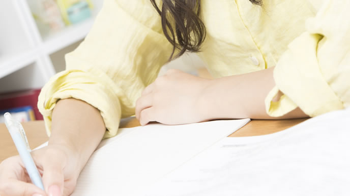 届いた手紙の返信を書くOL