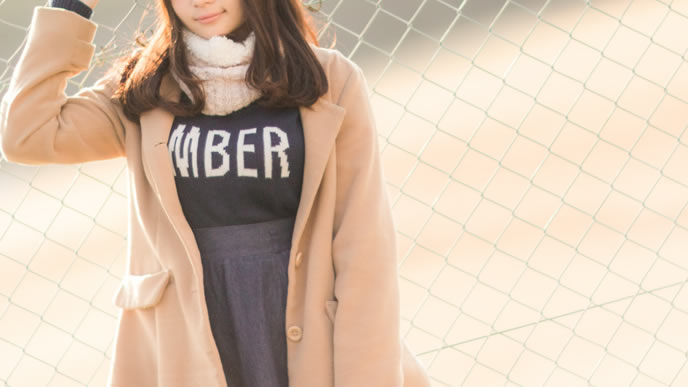 金網をバックに物思いにふける女性