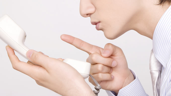 相手に聞こえていないかチェックする男性