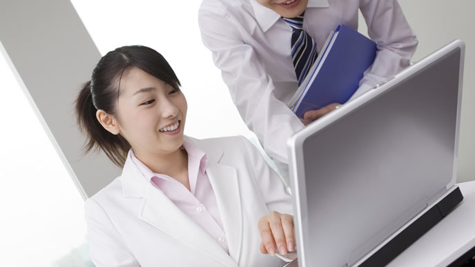 メールの送り方を指導する会社員