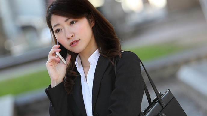 取引先に電話営業をする会社員