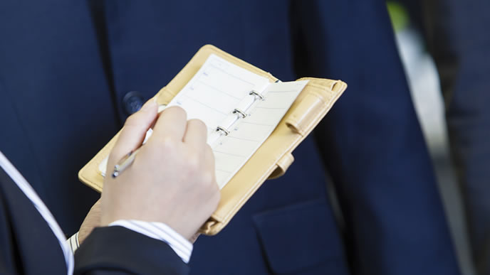 スケジュールをチェックする新入社員