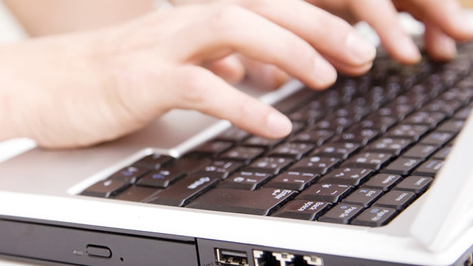 パソコンで「なので」を使った文書を書く男性