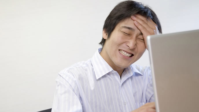 ビジネスメールの返信に苦悩する中年サラリーマン