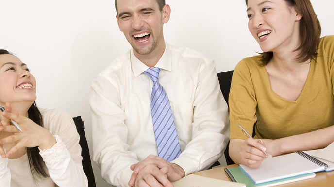 海外勤務の社員と会話を楽しむOL