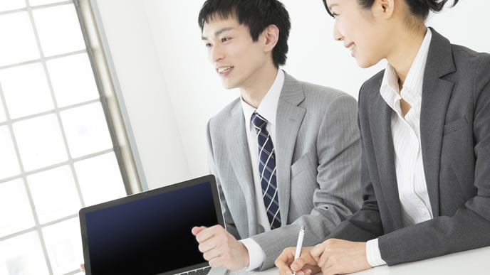 営業先で商品を提案するビジネスマン