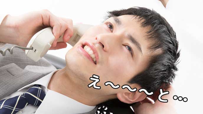 電話でとっさに敬語が出なくて考えているスーツ姿の男性