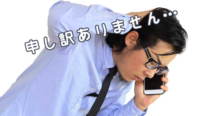 電話を掛けながら謝罪している男性