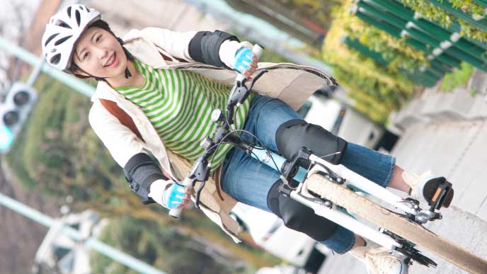 笑顔で自転車通勤しているヘルメットを被った女性