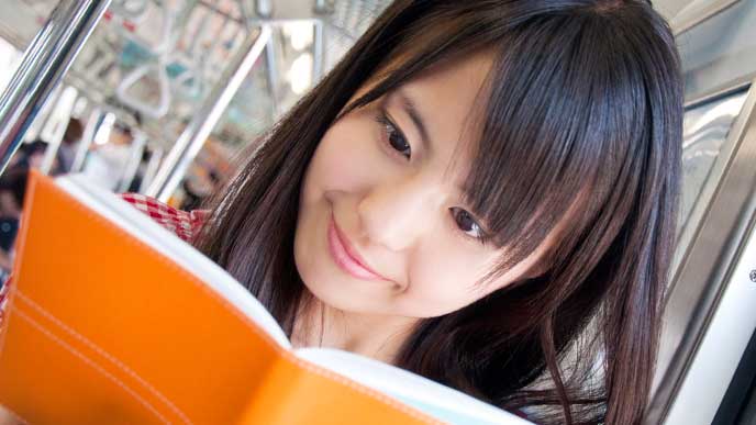 通勤時間に本を読んでる女性