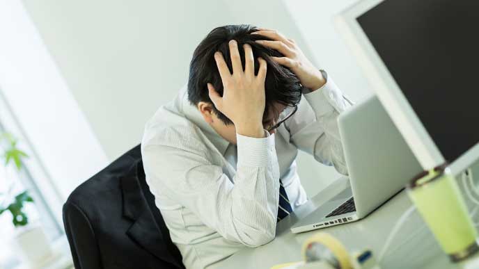 失敗して頭を抱えている男性社員