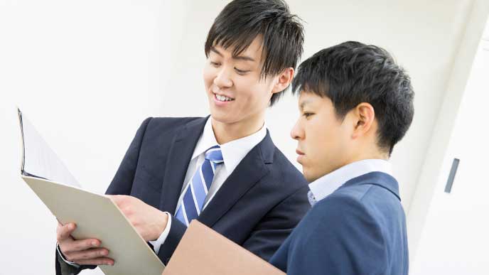 先輩からアドバイスを受けている男性会社員