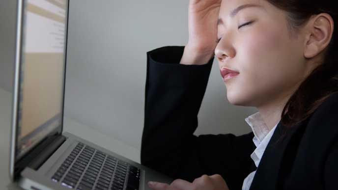 遅くまで残業してPCの前で居眠りしてる女性