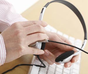 インカムを手に持つ女性オペレーター