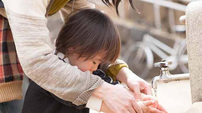 子供の手を洗ってあげる保育士
