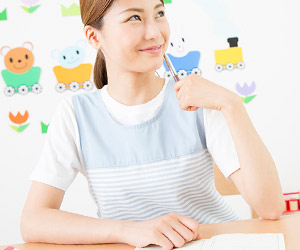 ペンを持ちながら制作アイデアを練る女性