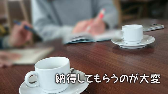 机の上に資料を置いて話し合うお客とコーディネーター