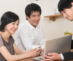 ノートブックで説明を受ける笑顔の夫婦